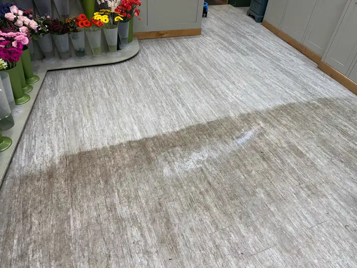 Florist's vinyl floor halfway through a deep clean, showing the cleaned and uncleaned halves