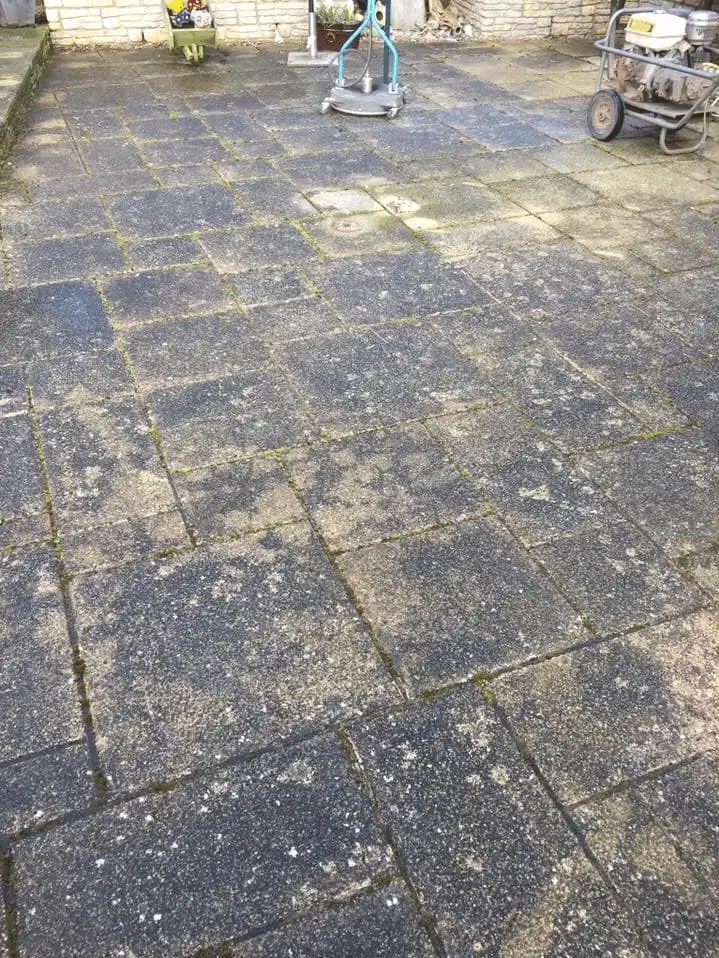 Patio slabs blackened with moss and algae before cleaning